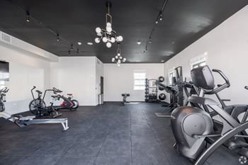 a gym with various machines and bikes in it